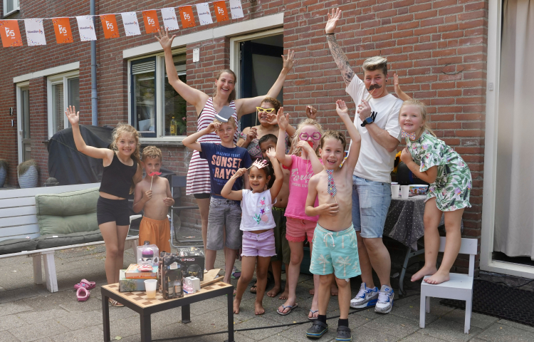 Kinderen in de Dr. J. Presserstraat die met hun handen in de lucht staan uit blijdschap